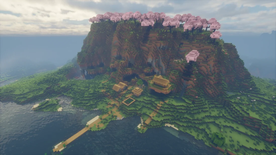 minecraft village below a cherry grove mountain